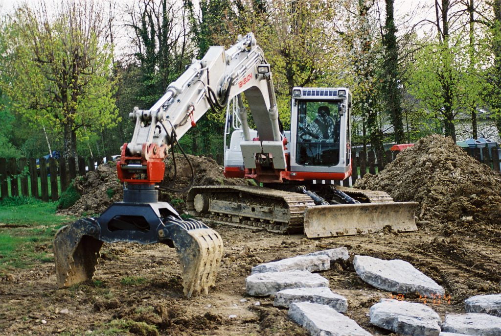 Maquinaria de excavación compacta en obra con mini excavadora y máquina de movimiento de tierras, lista para tareas de construcción y demolición en proyectos de obras públicas y reformas.