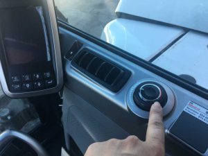 Controles interiores de una maquinaria de construcción, radiador y panel de instrumentos del vehículo en el cockpit.